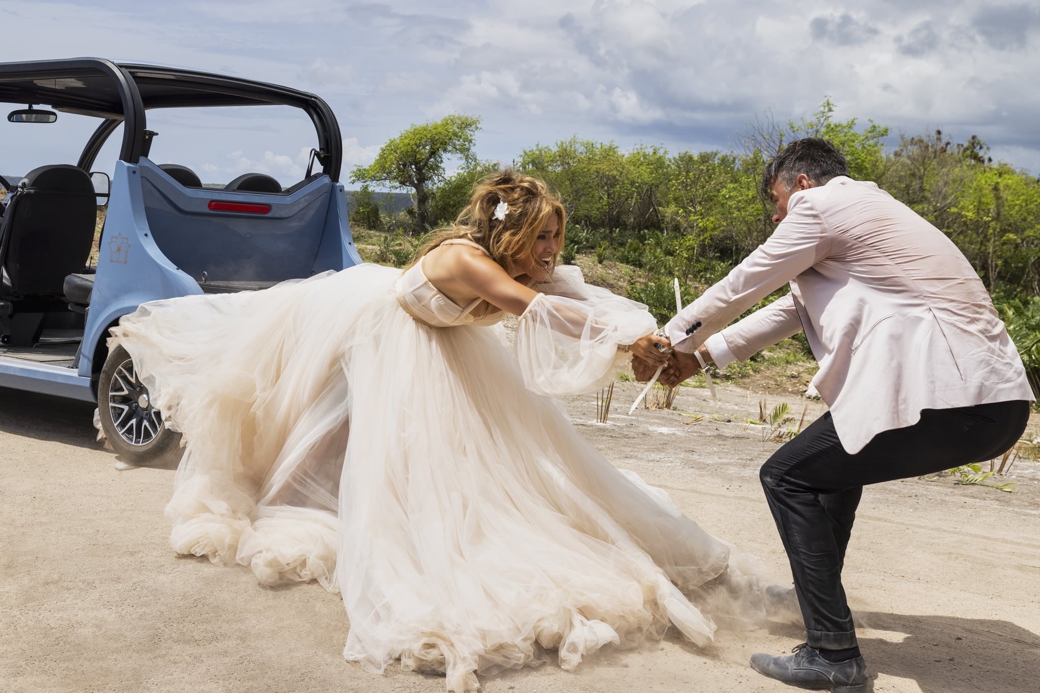 J.Lo and Josh Duhamel Try to Survive Their Nuptials (Literally) in the New “Shotgun Wedding” Trailer